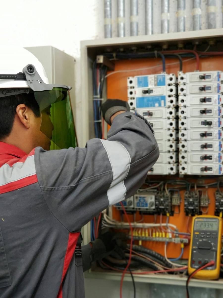 Eletricista trabalhando num quadro de disjuntores